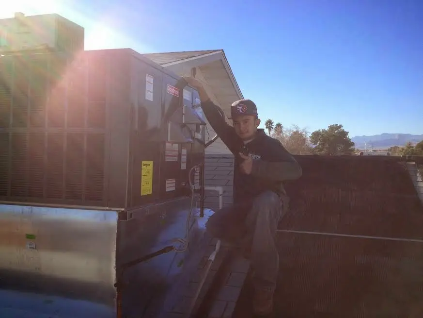 HVAC technician performing AC Tune-Up on a rooftop unit in Birch Bay